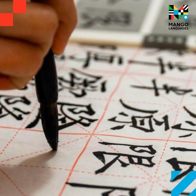 A person writing Chinese characters on a paper